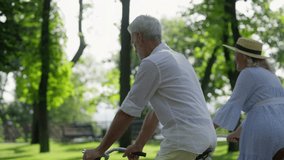 Back view of cute senior couple enjoying their first date outdoors, cycling - Powered by Shutterstock - Get 15% off with code: PIKWIZARD15