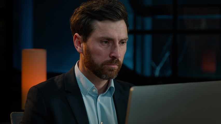 Adult businessman sad 40s caucasian man entrepreneur work with computer in evening office tired exhausted male worker fail online job read bad news receive rejected email financial loss difficulties Royalty-Free Stock Footage #1100618409