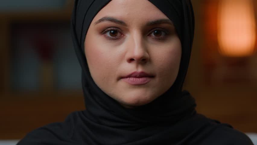 Portrait woman 20s arabian muslim young girl islamic lady in black hijab oriental traditional fashion headscarf. Businesswoman female Islam religion model looks at camera healthy face close-up indoors | Shutterstock HD Video #1100618421