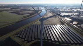 Reflection on solar panels with windmill turbine in the foreground and bio mass and water cleaning facility in The Netherlands part of sustainable industry aerial circular economy concept. - Powered by Shutterstock - Get 15% off with code: PIKWIZARD15