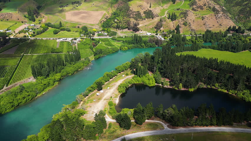 Pinders Pond - Picturesque Serene Lake Surrounded By Lush Greenery On The Banks Of Clutha River In Otago, New Zealand. aerial orbit