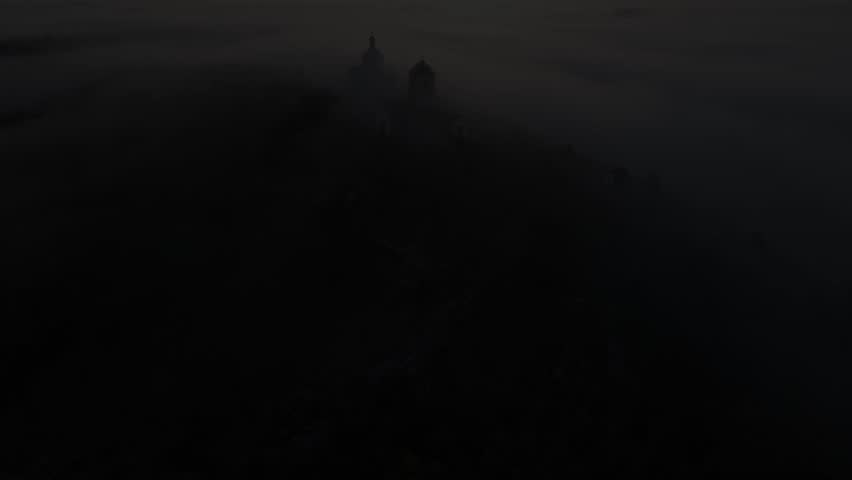 Aerial shots of the Holy Hill in Mikulov. Thick fog drifting over the hill on which the Christian chapel stands. 