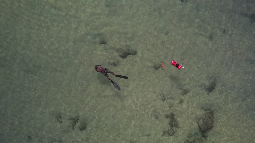 Aerial top down drone view of unidentifiable male snorkeler divers in Cascais, Portugal