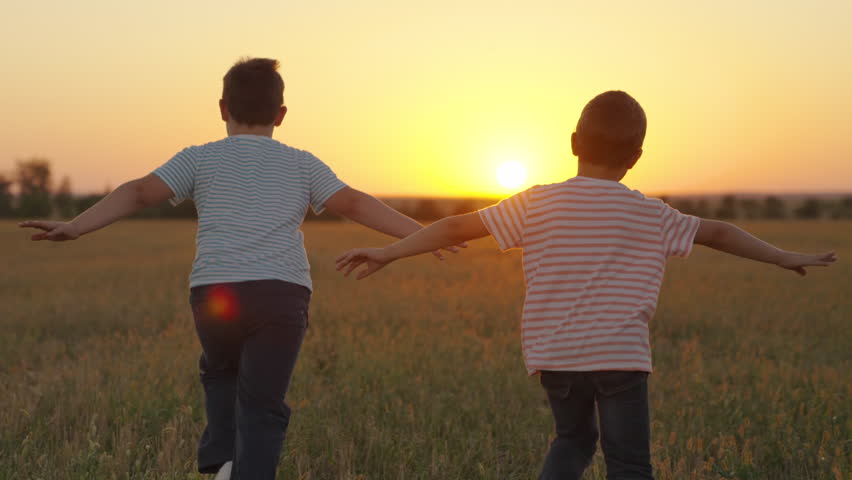 Kids play superheroes, nature. Boys friends, aviators run with their hands raised like an airplane across field in rays of sunset. Children want to become an astronaut. Teenager dreams of flying | Shutterstock HD Video #1100627867