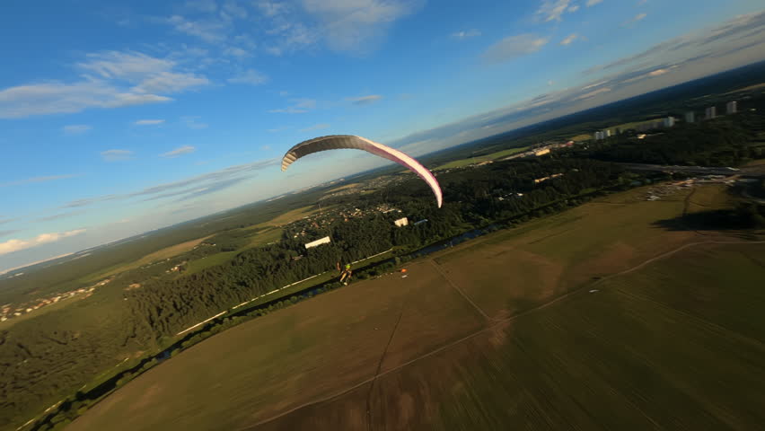 Alone paraglider flying during beautiful sunset, Paraglider flying above the forest, fpv drone flies above his head Extreme sports, paragliding. High quality 4k footage