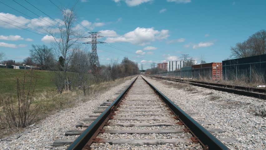 View of railroad track from the bottom of the train. Imitation of train rides at railway track. View from the front of the train. Railway track aerial slow hovering over train rails. Royalty-Free Stock Footage #1100629903