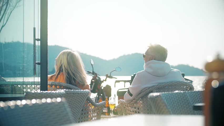 Unknown seniors spend time together in a seaside cafe. Wintering in warm county | Shutterstock HD Video #1100630239