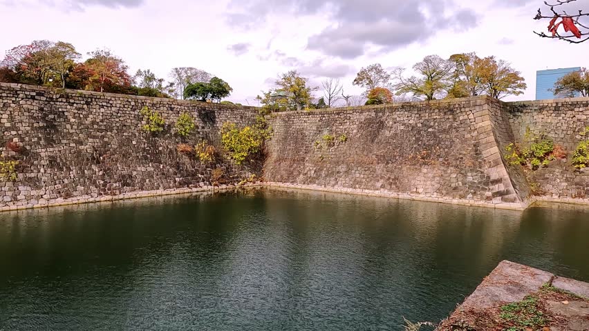 view over the Osaka castle moat and defense walls famous Osaka landmark in Japan. Beautiful samurai fortress and its steep stone walls