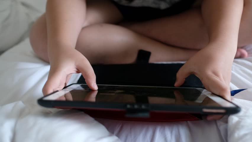 close up hand typing tablet, kid playing game
