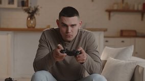 Close-up of a young man focused on playing a game console. A man screams with joy after passing a very difficult level in the game. - Powered by Shutterstock - Get 15% off with code: PIKWIZARD15
