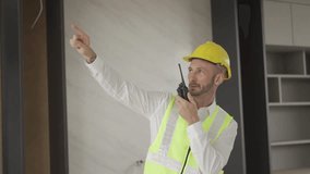 Engineers use walkie-talkies to communicate with crews while working in a factory. Foreman gives work instructions, talks using a walkie-talkie, works at a construction site. - Powered by Shutterstock - Get 15% off with code: PIKWIZARD15