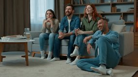Four diverse ethnicity friends watch television at home cinema people spectators watching smart tv channel comedy show serial movie multiracial african american caucasian women men laughing enjoy film - Powered by Shutterstock - Get 15% off with code: PIKWIZARD15
