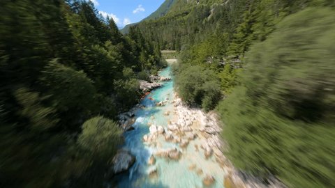 FPV aerial footage crossing a crystal clear river very fast in a beautiful day in Soca Valley, Slovenia Video Stok