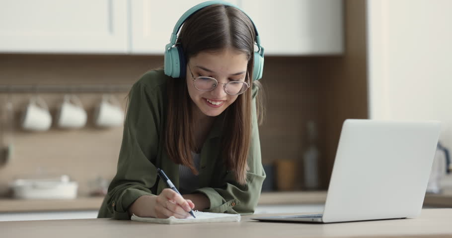 Pretty teenager in headphones take part in class with tutor or schoolmate prepare common task, talking, take notes, make exercise with help of on-line teacher. Education, videocall, e-learn, tuition Royalty-Free Stock Footage #1100656585