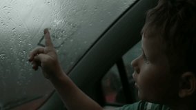 The child draws pictures with his finger on a wet misted window on a cloudy day. Creative. Boy drawing silhouette of a house. - Powered by Shutterstock - Get 15% off with code: PIKWIZARD15