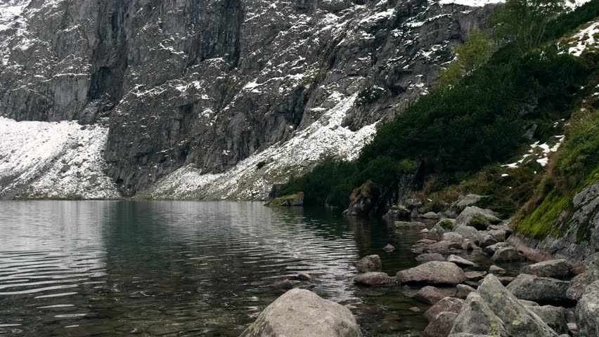 Czarny Staw under Rysy, Mountain lake pond, Tatry National Park, Poland. Snow covered mountain peaks. Winter adventure tourism