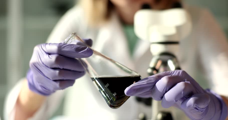 Scientist analyzes crude oil in laboratory flask