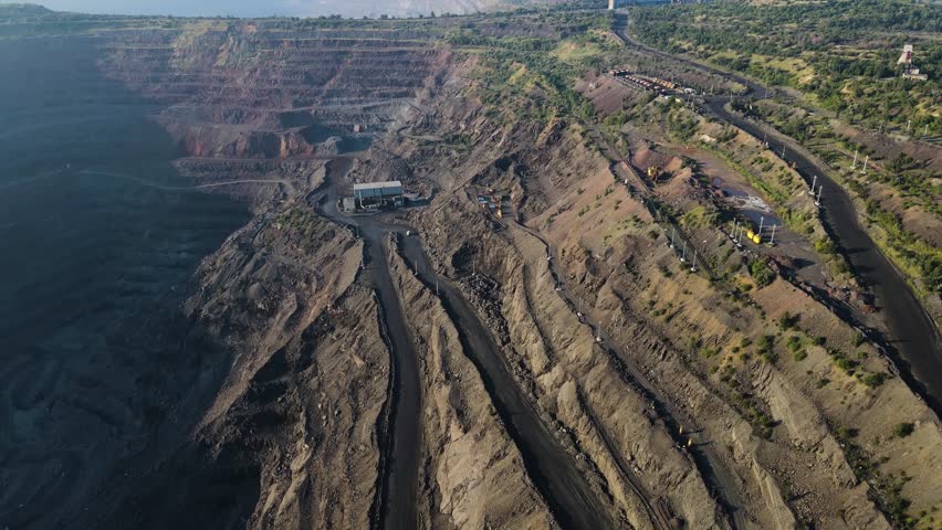 Panorama aerial view shot open pit mine coal mining, dumpers, quarrying extractive industry stripping work. Big Yellow Mining Trucks. View from drone at opencast mining with lots of machinery trucks