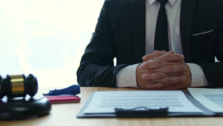 Young Asian legal advisor or lawyer doing document approval stamp Business agreements regarding real estate financial documents at the office. Royalty-Free Stock Footage #1100668011
