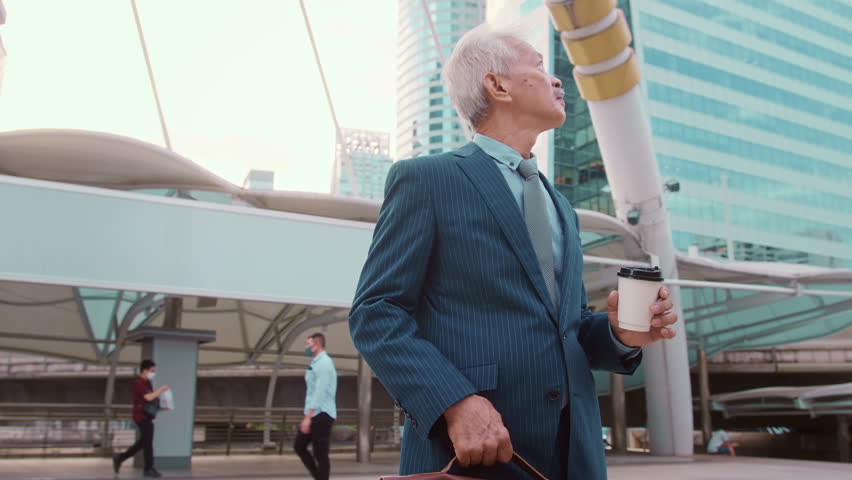 Portrait of Asian senior mature middle aged businessman in modern city


