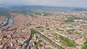 Inscription on video. Verona, Italy. Flying over the historic city center. Roofs of houses, summer. Arises from blue water, Aerial View