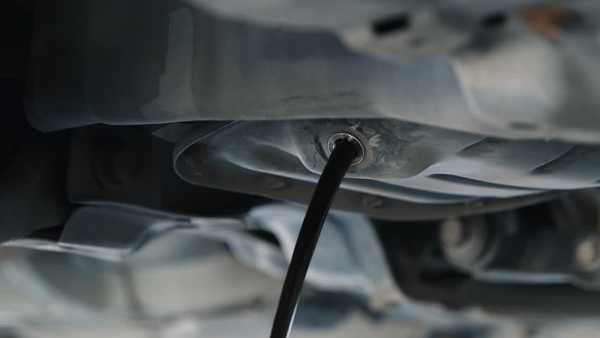 The oil is flowing from the engine under the car while the engine oil changes. To maintain and extend the life of the car. Royalty-Free Stock Footage #1100676861