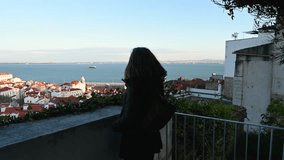 Woman admiring the sunset in lisbon on a terrace