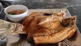 Traditional Thai Cuisine. Close-Up of Deep-Fried Sea Bass with Fish Sauce