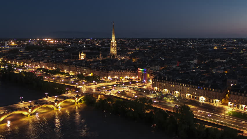 Establishing Aerial View Shot of Bordeaux Fr, world capital of wine, Nouvelle-Aquitaine, France at night, evening, city center circling left