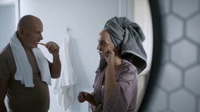 Senior couple in bathroom, brushing teeth and washing, morning routine concept. - Powered by Shutterstock - Get 15% off with code: PIKWIZARD15