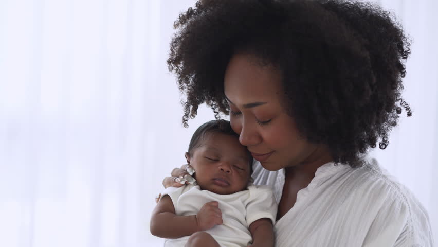 Beautiful African American Mother holding sleep newborn baby child in her arms and kiss cheek in hospital. Healthcare medical Black family lovely, nursery breastfeeding mother’s day. Royalty-Free Stock Footage #1100683857
