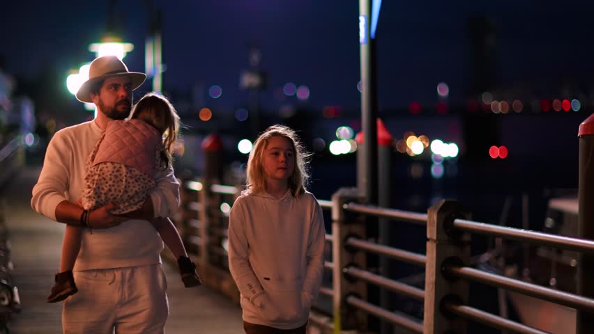 people, tourists walking along the riverfront embankment on the warm autumn evening