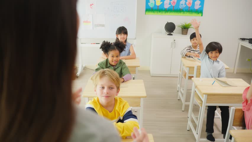 Group of student learn with teacher in classroom at elementary school. Attractive beautiful female instructor master explain and educate young children with happiness and fun activity at kindergarten. Royalty-Free Stock Footage #1100690161