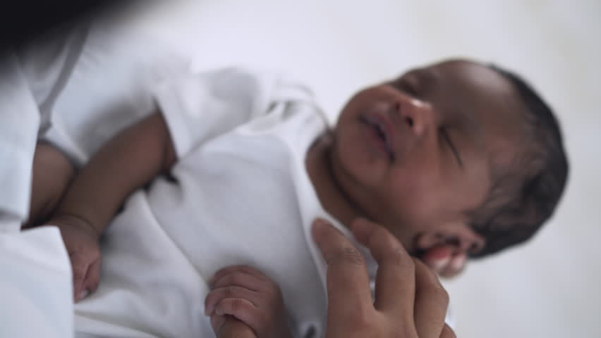 Close up of newborn baby in a tender embrace. Portriat of African American mother holding sleeping infant child on hands. Black Mother hugging her little in hospital. Family breastfeeding mother’s day Royalty-Free Stock Footage #1100693853