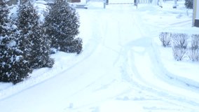 4 to the video, the entrance to a snow-covered park with a barrier on during a heavy snowfall on the street. Poor visibility on an empty fork in the road