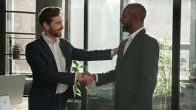 Company representative handshake diverse men partners coming at office meeting come in boardroom Caucasian businessman shake hands welcome African American negotiator man talking respect handshaking - Powered by Shutterstock - Get 15% off with code: PIKWIZARD15