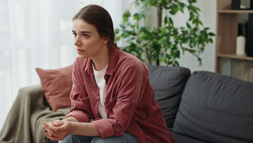 Sad Worried Caucasian Woman Having Psychological Problem Feeling Anxiety Depression, Sitting on Couch at Home. Upset Lonely Girl Thinking of Problems Sit Alone. Unwanted Pregnancy | Shutterstock HD Video #1100698307