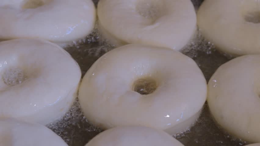 Making donuts while Donut batter is being fried in hot oil