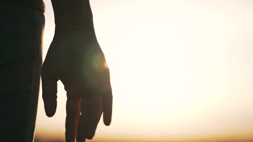 Silhouette of parent, small child holding hands at sunset. Happy family holding hands together. parent takes care of child. Hands at sunset silhouette. Take child by hand. Royalty-Free Stock Footage #1100699283