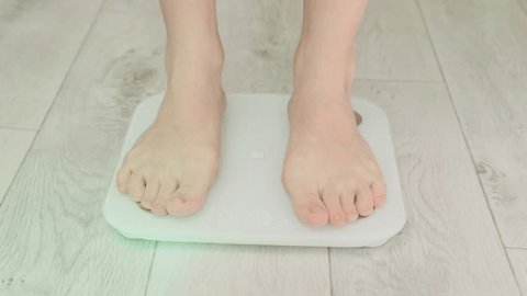 Woman standing on fitness scale, Stock Video