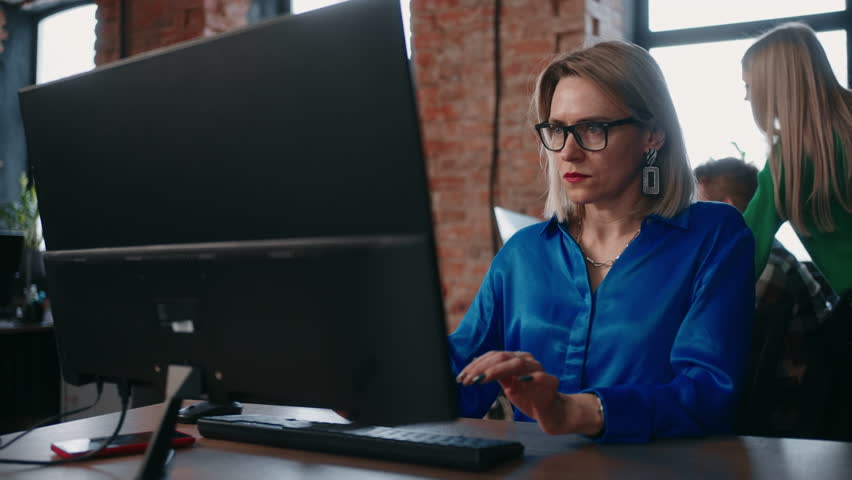 Attractive Middle-Aged Woman Entrepreneur Working In Office, Portrait Against Co-Workers