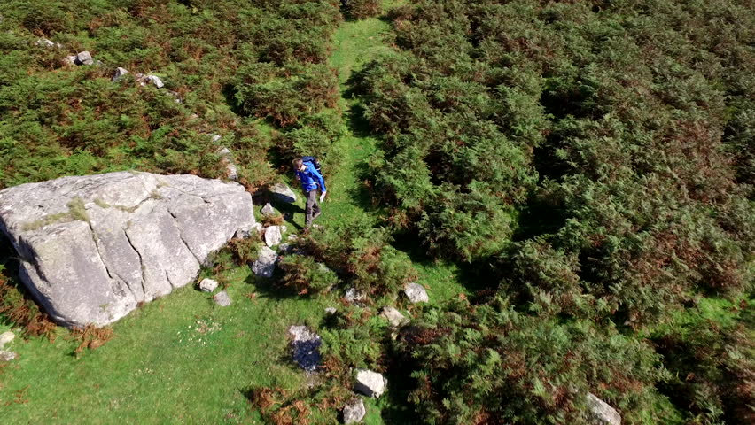 Dartmoor National Park, landscapes with hiker carring backpack for wild camping. Drone footage, amazing views.
