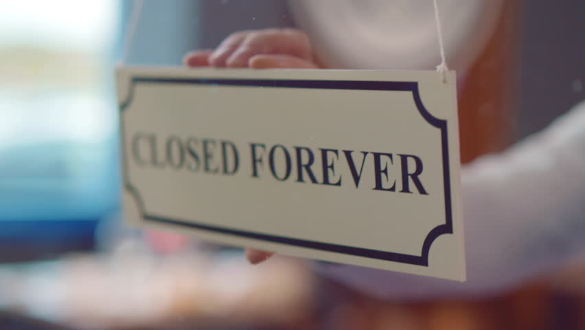 Business owner hangs the sign on the front door with the inscription closed forever. Close up of closed forever sign hanging on glass door or window of cafe or store. Small business bankrupt. Realtime