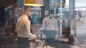 Manager in safety mask screening temperature of waiters. Prevention due to coronavirus pandemic, covid-19 epidemic. Cafe workers measure temperature before working day. Realtime - Powered by Shutterstock - Get 15% off with code: PIKWIZARD15