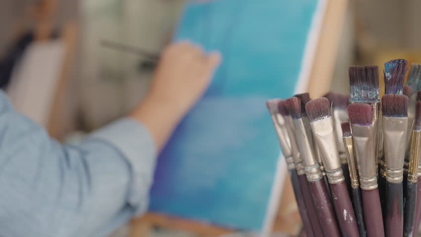Closeup active asian people relax blend blue orange color prepare draw picture artwork on paper stress relief. Talent craft painter skill mix oil stain tools on plate in studio workspace table desk. Royalty-Free Stock Footage #1100740453