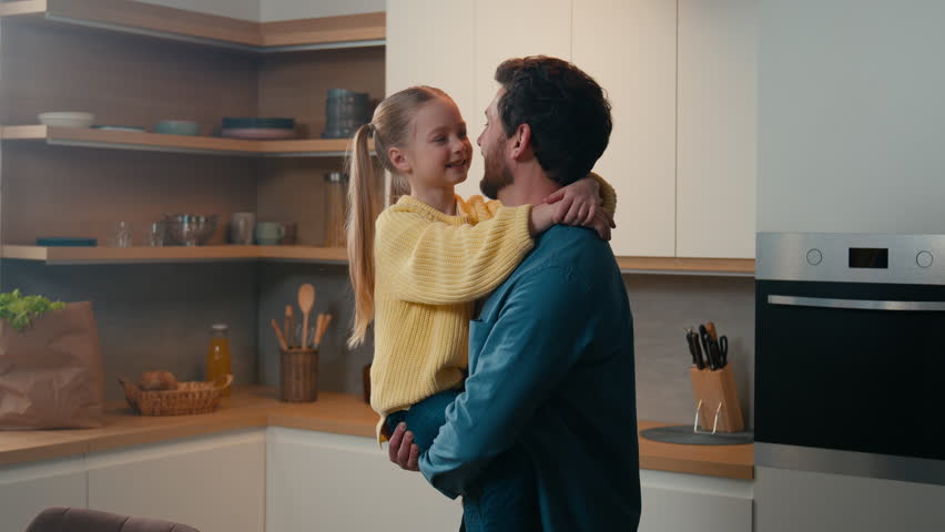 Adult man father holding spinning lovely daughter spin child around swirling kid in kitchen. Loving dad and little girl touch noses fooling enjoy bonding hugging embracing cuddling together at home Royalty-Free Stock Footage #1100745757