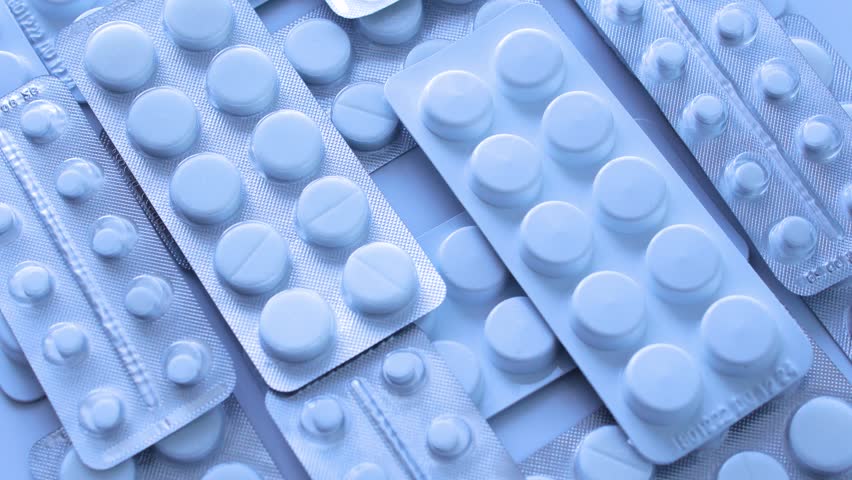 A lot of medicaments in blisters lying on table, drug testing and medical research, placebo-controlled clinical trial, active or inactive treatment, close-up view to tablets Royalty-Free Stock Footage #1100748811