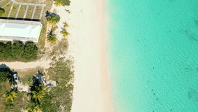 Rendezvous Bay beach on the Caribbean island of Anguilla. Beautiful paradisiacal beach with crystalline waters. Drone flight with 4k video. Beautiful boat with people swimming and snorkeling.