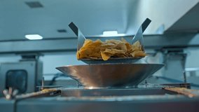 Slow Motion Shot of Potato Chips falling into a sorting container in a facility.
