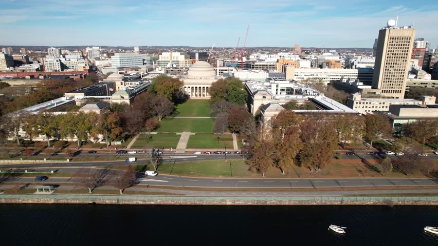Aerial of MIT over the Charles River and Harvard Bridge in Boston Massachusetts, Institute of Technology during clear blue sky day